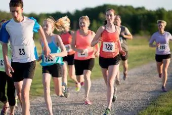 Multietnická skupina dětí a dospělých spolu běží závod