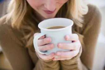 Người phụ nữ cầm cốc cà phê