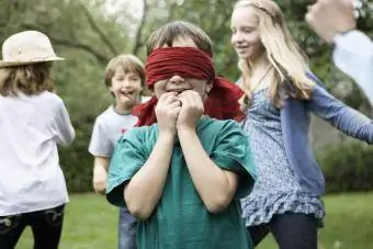 Enfant aux yeux bandés jouant à un jeu