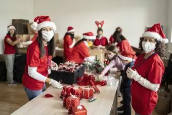 Mulheres voluntariando na preparação de presentes de Natal