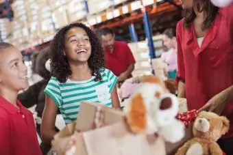 Adultos e crianças doando brinquedos em campanha beneficente de Natal