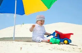 kumsalda oynayan erkek bebek