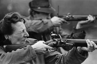 donna che spara a un pezzo dell'esercito britannico chiamato fucile a pietra focaia Brown Bess
