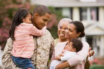 Padre militar afroamericano abrazando a la familia