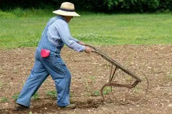 farmár so starožitným kultivátorom