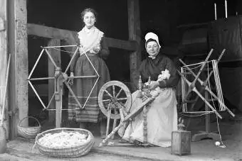 To kvinder med et spindehjul og en garnopruller