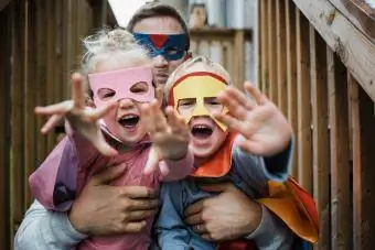 Ritratto di bambini con padre in costumi da supereroe