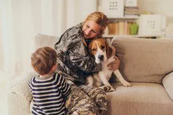 Bienvenido a casa mamá soldado con cachorro