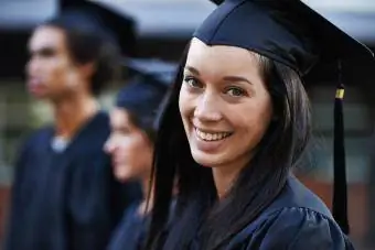 Imagem de uma graduada e turma sorridente