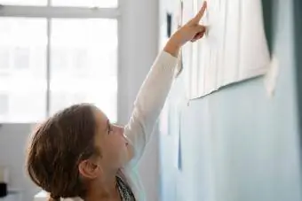 ילדה מצביעה על נייר על הקיר