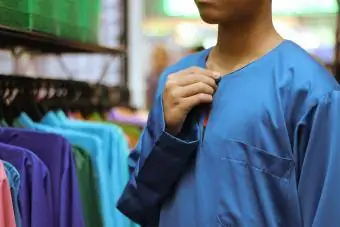 ילד מנסה ללבוש חולצה כחולה בחנות