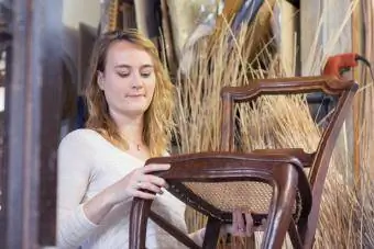 Antika sandalyeyi inceleyen genç kadın