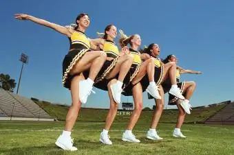 Cheerleaders danser arm i arm i formation