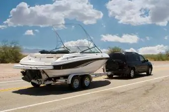 zwarte suv die een boot sleept