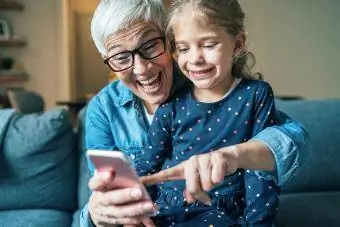 mormor och barnbarn spelar smartphone