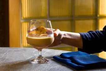 Isang kamay na may hawak na Baileys cocktail glass