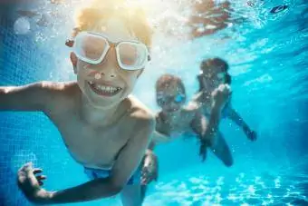 Crianças brincando debaixo d'água na piscina