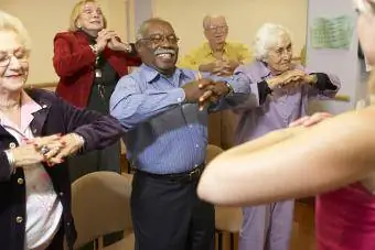 Idosos em aula de alongamento