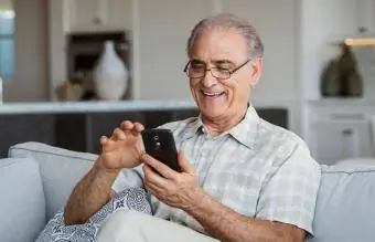 Uomo anziano che manda SMS al cellulare
