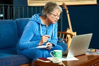 Vanhempi nainen käyttää kannettavaa tietokonetta