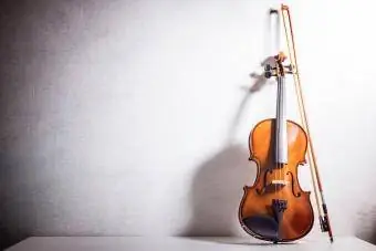 Violin antik bersandar pada dinding kosong