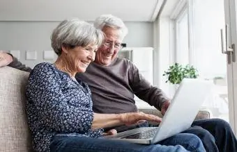 vanhempi pariskunta käyttää kannettavaa tietokonetta
