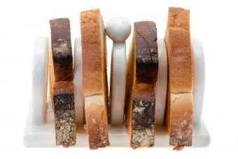 Tostirane kriške kruha na stalku za tost od bijelog porculana