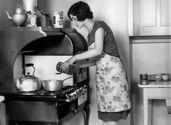 20. gadsimta 20. gadu mājsaimniece, kas gatavo pie plīts