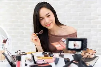 Vlogger kecantikan profesional wanita merakam video tutorial solek