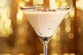 koktajl z začimbami iz buče v kozarcu za martini na zlatem ozadju