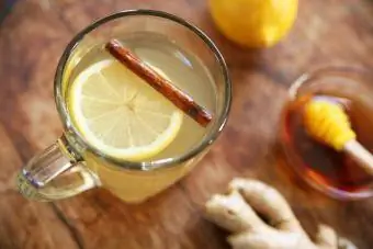 Mainit na whisky toddy na inumin na may lemon, honey, cinnamon, at luya