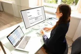 Mujer trabajando en facturas en computadora