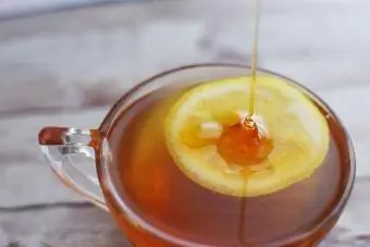 Мед, налят върху лимон в чаша с Honey Toddy