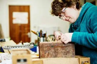 kvinna som binder en antik bok för restaurering