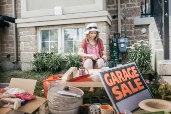 Fată tânără care ține o vânzare de garaj pentru caritate