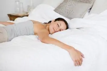 Wanita bahagia berbaring di tempat tidur