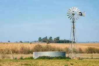 Bomba de agua de molino de viento con tanque en la granja