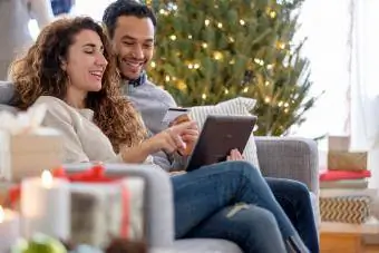 Pareja de compras con tableta digital en el sofá