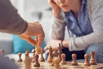 Žmonės kartu žaidžia šachmatais