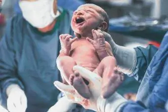 Doctores sosteniendo al bebé recién nacido