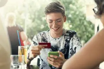 Tenåringsgutt som bruker kredittkortet sitt
