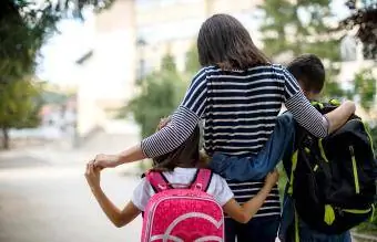 Mãe levando os filhos para a escola